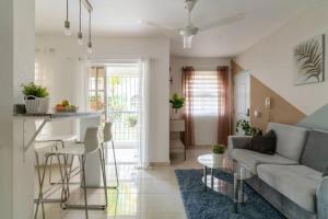 ein Wohnzimmer mit einem Sofa und einem Tisch in der Unterkunft Cozy 2 bdr condo, with pool area and free WIFI in Punta Cana
