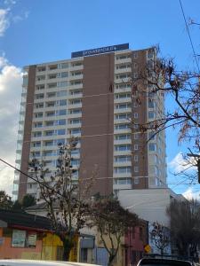 een hoog gebouw met een bord erop bij Departamento Centro Chillan in Chillán