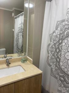 a bathroom with a sink and a shower curtain at Departamento Centro Chillan in Chillán
