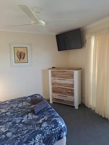 een slaapkamer met een bed en een dressoir bij Villa 20 in Tangalooma