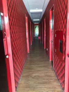 einen langen Korridor mit roten Wänden und Holzböden in der Unterkunft My Family Hotel in Port Dickson