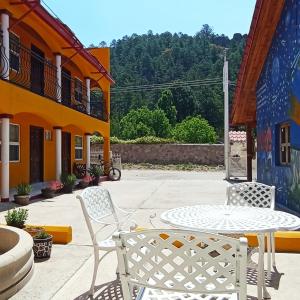 un patio con mesa y sillas en un edificio en Hotel Ecológico Temazcal, en Creel