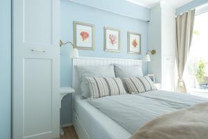 a bedroom with blue walls and a bed with a window at Panoramic App C03-4 Sonnendeck in Sierksdorf +13 photos