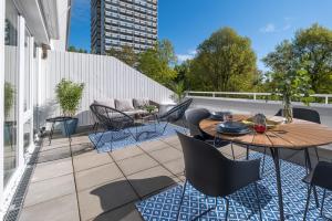 a patio with a table and chairs on a balcony at Panoramic App C03-4 Sonnendeck in Sierksdorf