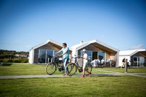 zwei Leute stehen mit ihren Fahrrädern auf einem Bürgersteig in der Unterkunft Apelvikstrand in Varberg