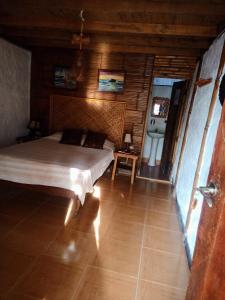 a bedroom with a bed in a wooden room at Guacamayo Bed & Breakfast in Máncora