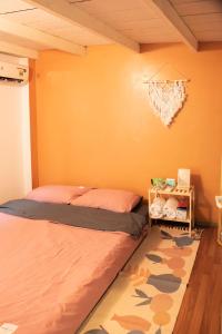 Schlafzimmer mit orangefarbenen Wänden, einem Bett und einem Teppich in der Unterkunft La Luna Quy Nhon in Quy Nhon