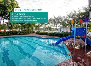 a pool at a hotel with a blue water slide at Desaru Homestay by Home Cube in Desaru