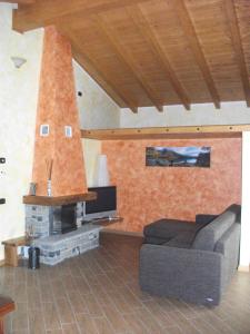a living room with a couch and a fireplace at Agriturismo Il Sorriso dei Figli in Argegno