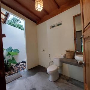 a bathroom with a toilet and a fish tank at Kambuna Bungalow in Krui