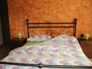 a bed with a comforter and pillows on it at Agriturismo Il Sorriso dei Figli in Argegno