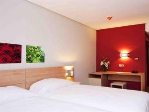A bed or beds in a room at Manzil Hotel