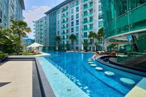 a large swimming pool in front of a building at City Center Residence by Tech in Pattaya Central