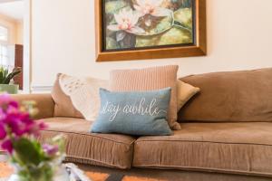 a brown couch with a pillow that says happy awhile at West Park Gardens in Culpeper