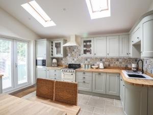 a kitchen with white cabinets and a sink at Cosy Cottage in Menai Bridge