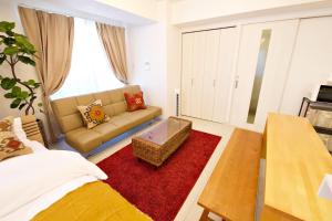 ein Wohnzimmer mit einem Sofa und einem roten Teppich in der Unterkunft ゆかるひ前島501 in Tomari