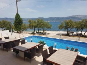 een patio met tafels en een zwembad bij Villa Ana in Slatine