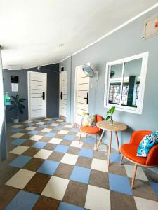 um átrio com cadeiras cor-de-laranja e um piso de xadrez em Sunny Terrace em Baler