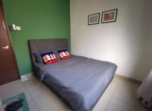 ein kleines Bett in einem Zimmer mit grünen Wänden in der Unterkunft Desaru Homestay by Home Cube in Desaru