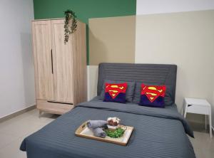 ein Schlafzimmer mit einem blauen Bett und Supermannkissen in der Unterkunft Desaru Homestay by Home Cube in Desaru