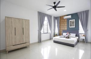 Schlafzimmer mit einem Bett und einem Deckenventilator in der Unterkunft Desaru Homestay by Home Cube in Desaru