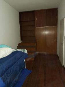 1 dormitorio con cama y armario de madera en AmaNi Tigre. Confort estrategico en Tigre