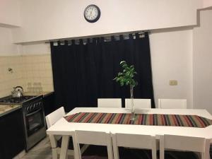 eine Küche mit einem Tisch und einer Uhr an der Wand in der Unterkunft AmaNi Tigre. Confort estrategico in Tigre