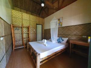 a bedroom with a bed with two swans on it at Loboc Cool River Resort in Loboc