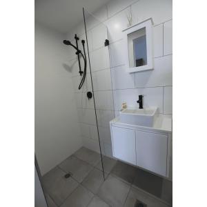 a bathroom with a shower and a sink at South Pacific Studio in Ulladulla