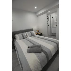 a white bedroom with a large bed with two pillows at South Pacific Studio in Ulladulla