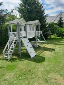 a play house with a slide in a yard at Pokoje przy Zamku in Podzamcze