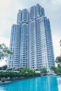 a large apartment building in front of a large building at Teega Suites by RR JBcity in Nusajaya