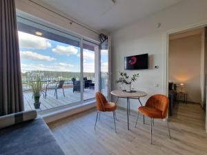 a living room with a table and chairs and a large window at MANO JŪRA 2 SILVER in Palanga