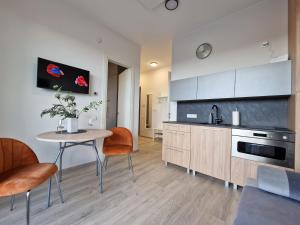 a kitchen with a table and a table and chairs at MANO JŪRA 2 SILVER in Palanga