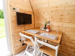 a desk in a tiny house with a tv at Meadow Lodge Berrys Place Farm in Gloucester