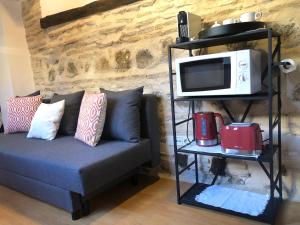 a living room with a couch and a microwave on a shelf at Apartamento Canónigo - terraza con vistas in Toledo