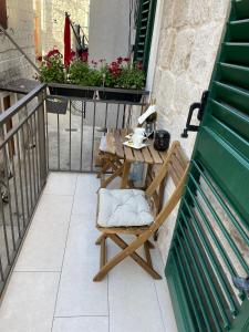 d'une table et d'une chaise en bois sur un balcon. dans l'établissement Rooms Marija, à Split