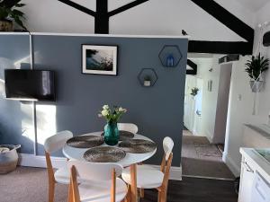 a dining room with a white table and chairs at Swift Cottage in Liskeard