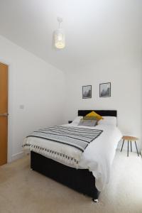 a bedroom with a bed with a black and white comforter at Royal Derby Hospital 2 Bed Town House in Derby