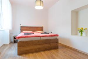 um quarto com uma cama de madeira num quarto branco em Apartmán Eliška em Nové Hute