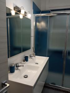 een badkamer met een witte wastafel en een douche bij Family apartment in Brindisi