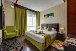 a hotel room with a bed and a chair at Sunday Marina View Hotel Apartments in Dubai