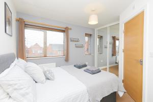 a bedroom with a white bed and a window at Royal Derby Hospital House (2.5 bath) in Derby