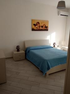 een slaapkamer met een bed en een schilderij aan de muur bij Family apartment in Brindisi