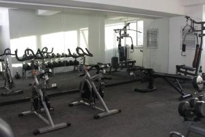 ein Fitnessstudio mit mehreren Heimtrainern in einem Raum in der Unterkunft A2J BGC Luxury 1BR Suite Near Burgos Circle & Mall in Manila