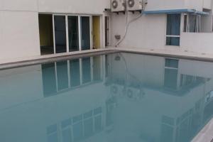 ein Swimmingpool mit blauem Wasser in einem Gebäude in der Unterkunft A2J BGC Luxury 1BR Suite Near Burgos Circle & Mall in Manila