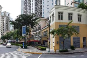 eine Stadtstraße mit einem Gebäude und einem Zebrastreifen in der Unterkunft A2J BGC Luxury 1BR Suite Near Burgos Circle & Mall in Manila