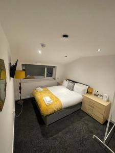 um quarto com uma cama grande e um cobertor amarelo em PCK THAS HOTEL em Blackpool
