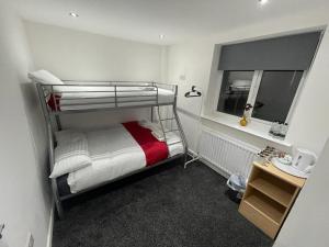 a small bedroom with a bunk bed with a window at PCK THAS HOTEL in Blackpool