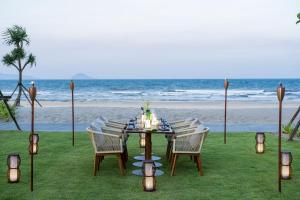 Hoiana Hotel & Suites في هوي ان: طاولة مع كراسي وإضاءة على الشاطئ